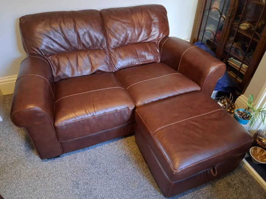 2 Dark brown DFS leather sofas plus foot stall with storage inside.
