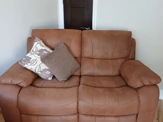 2 seater tan, reclining sofa and footstall