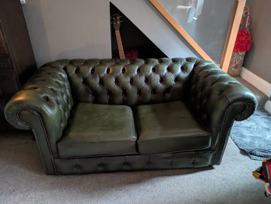 Green leather Chesterfield sofa bed.
