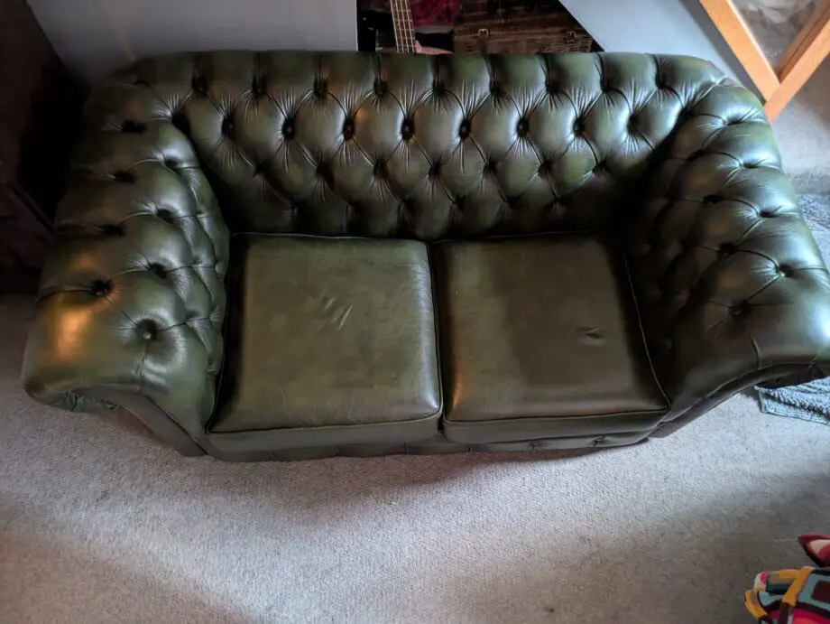 Green leather Chesterfield sofa bed.