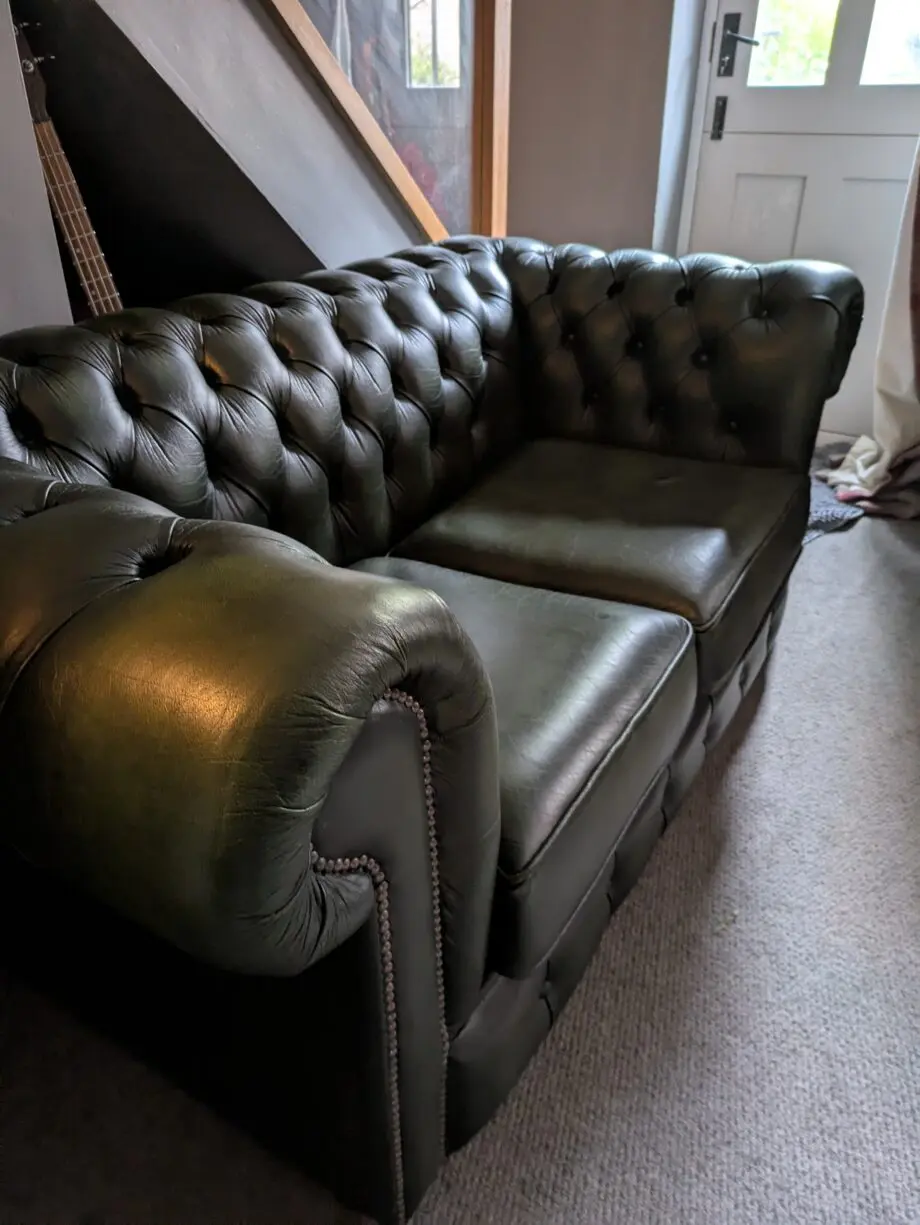 Green leather Chesterfield sofa bed.