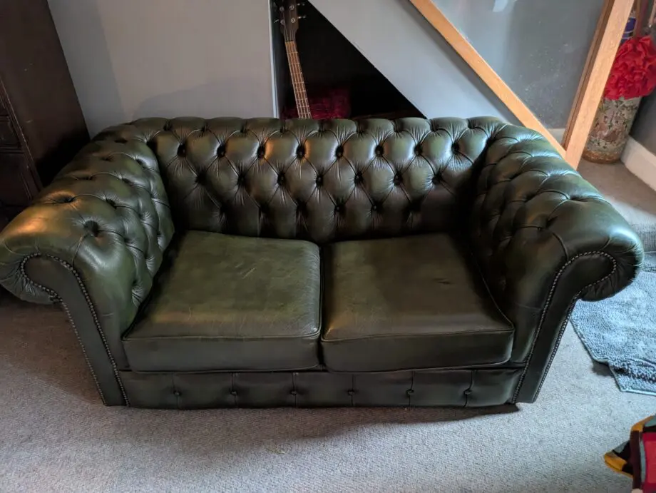 Green leather Chesterfield sofa bed.