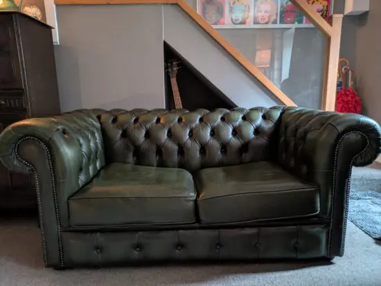 Green leather Chesterfield sofa bed.
