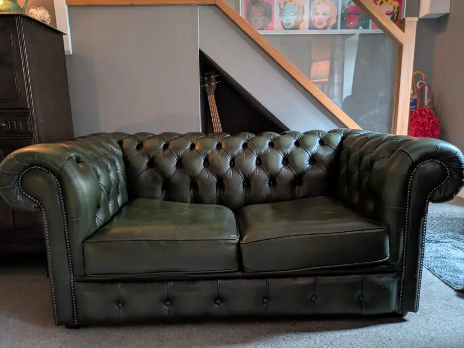 Green leather Chesterfield sofa bed.