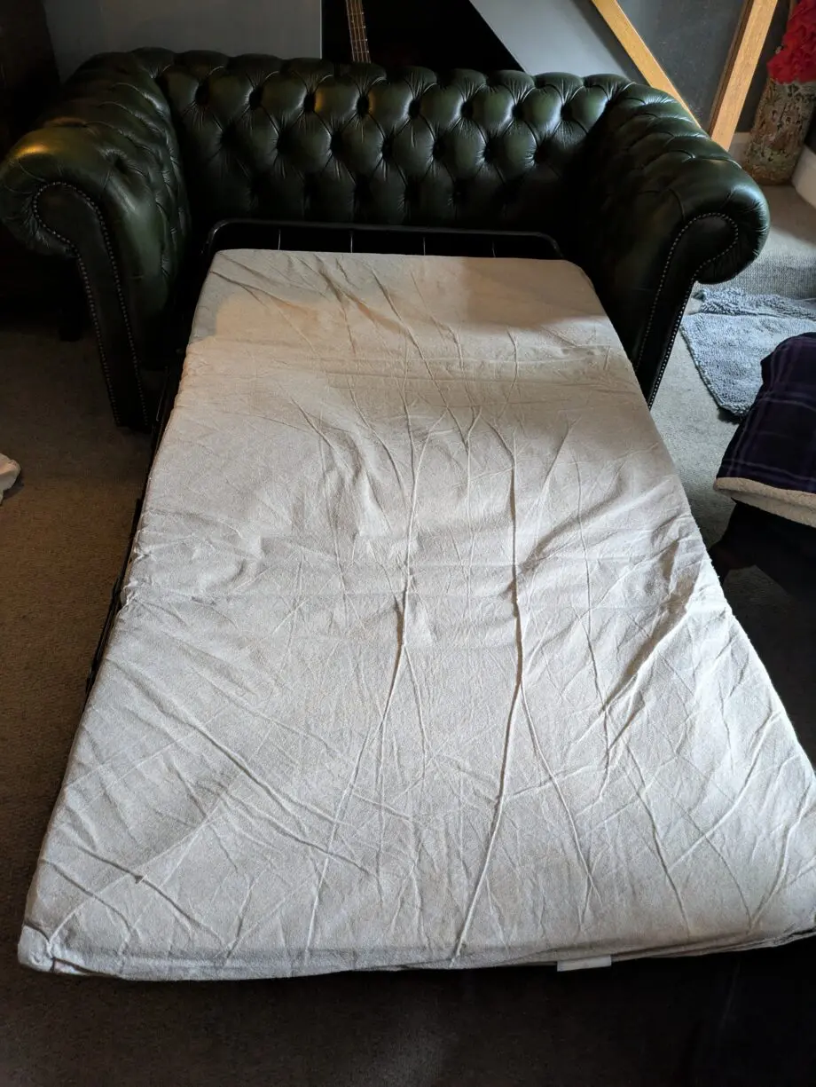 Green leather Chesterfield sofa bed.