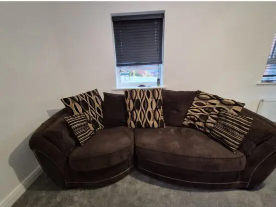 Brown and gold curved sofa, cuddle swivel chair and footstool