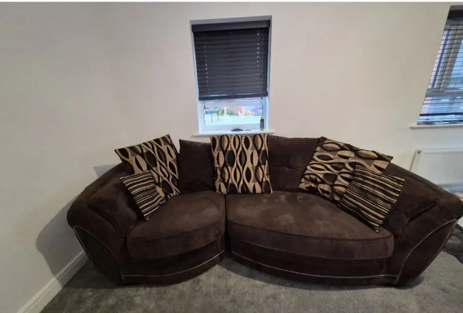 Brown and gold curved sofa, cuddle swivel chair and footstool