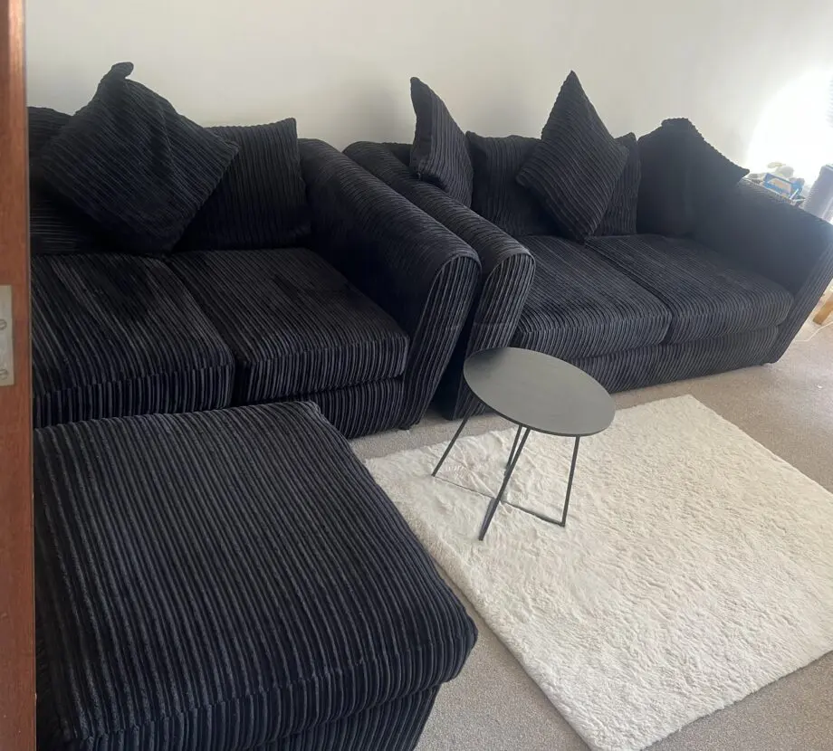 Black sofas and footstool