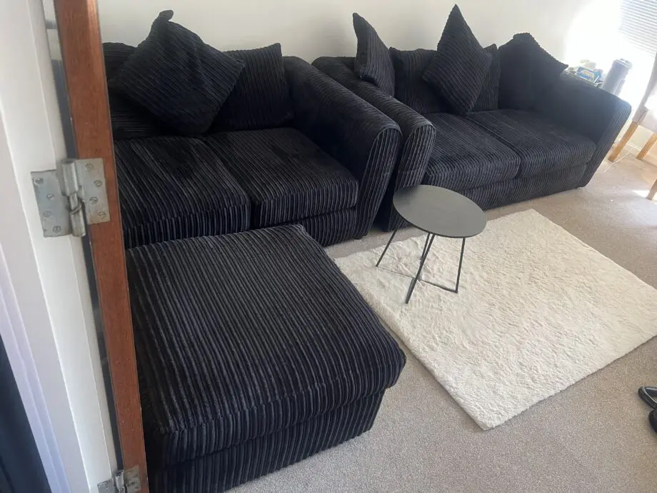 Black sofas and footstool
