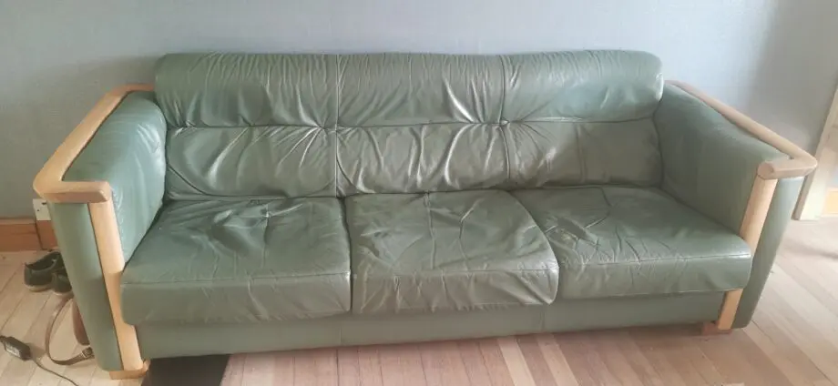 Ekornes leather sofa with oak arm trims.