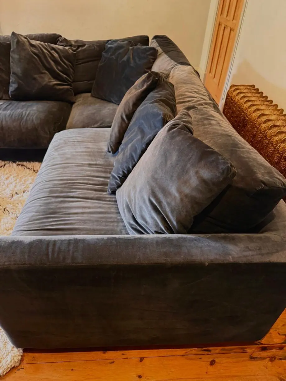 Navy blue velvet corner sofa with cushions