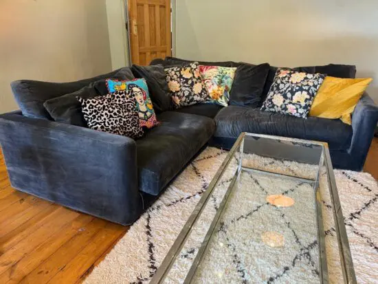 Navy blue velvet corner sofa with cushions