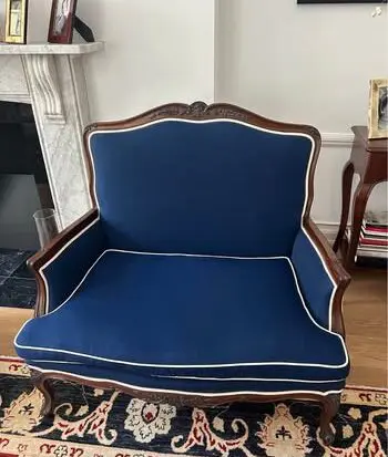 Blue loveseat with white piping