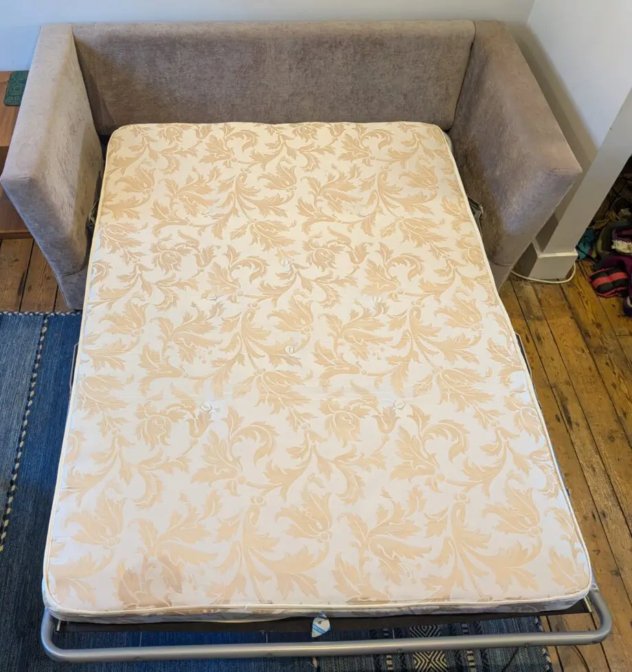 Light taupe three seat sofa bed in excellent condition