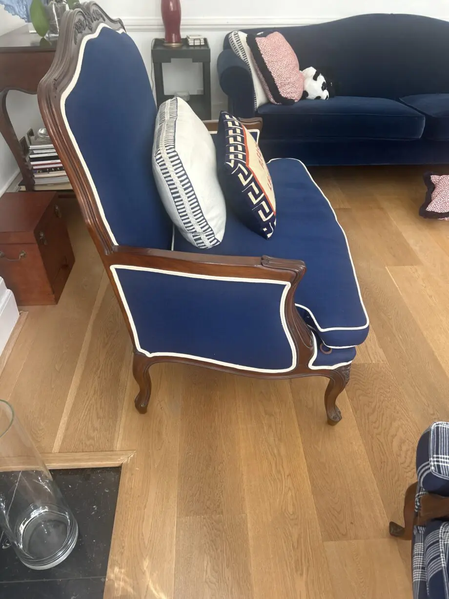 Blue loveseat with white piping