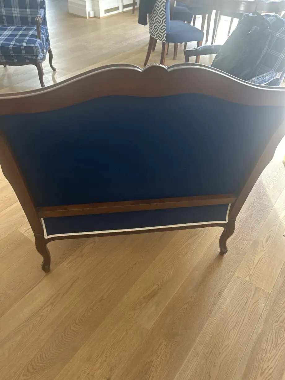 Blue loveseat with white piping