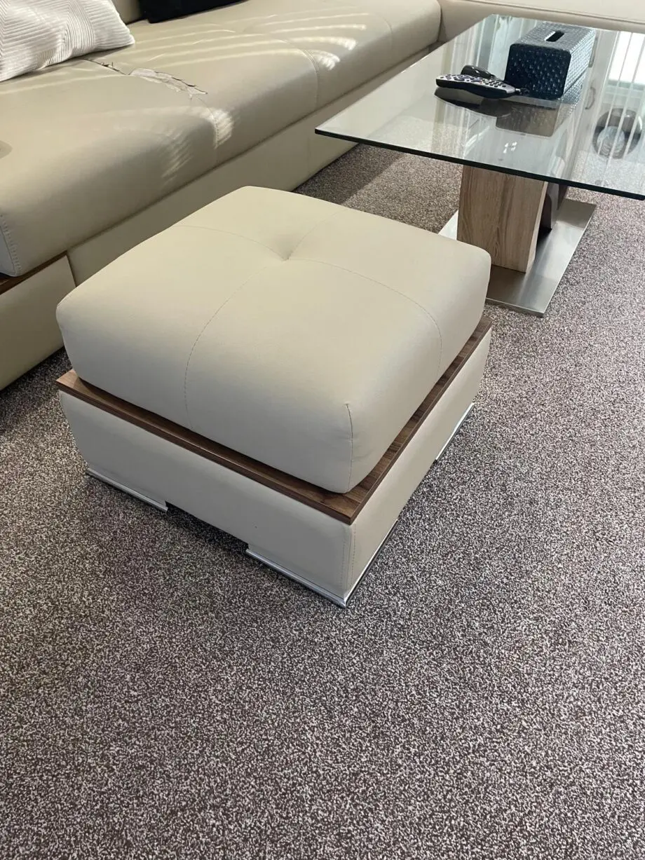 Modern beige/cream leather corner sofa with matching ottoman/footstool.