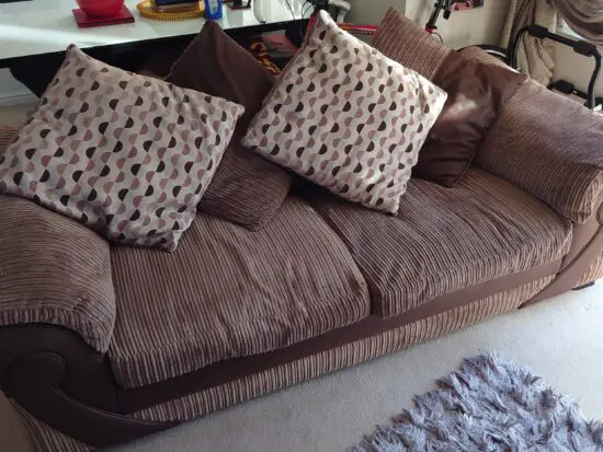 Good condition brown three seater sofa with four cushions