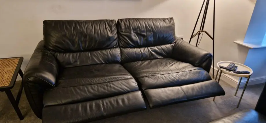 DFS black leather recliner sofas and footstool