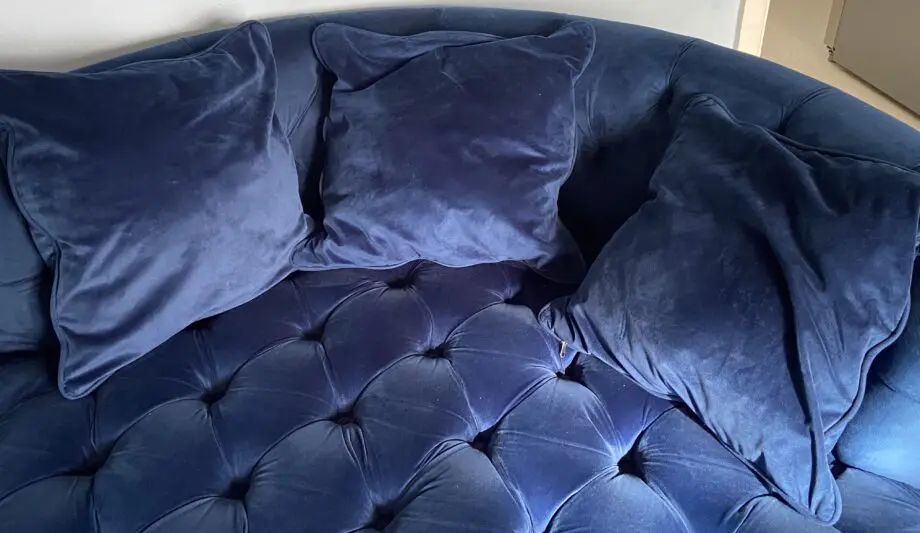 A luxurious navy blue velvet 2 seater loveseat