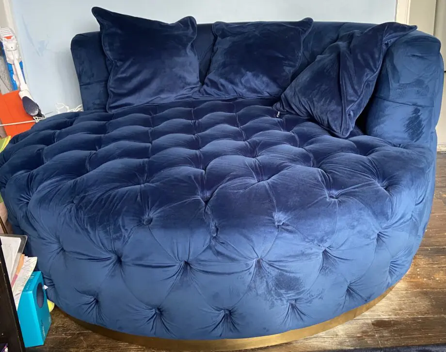 A luxurious navy blue velvet 2 seater loveseat