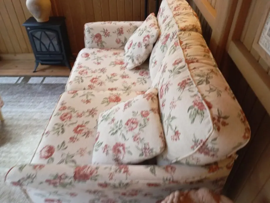 DFS 2 seater floral sofa with matching foot stool