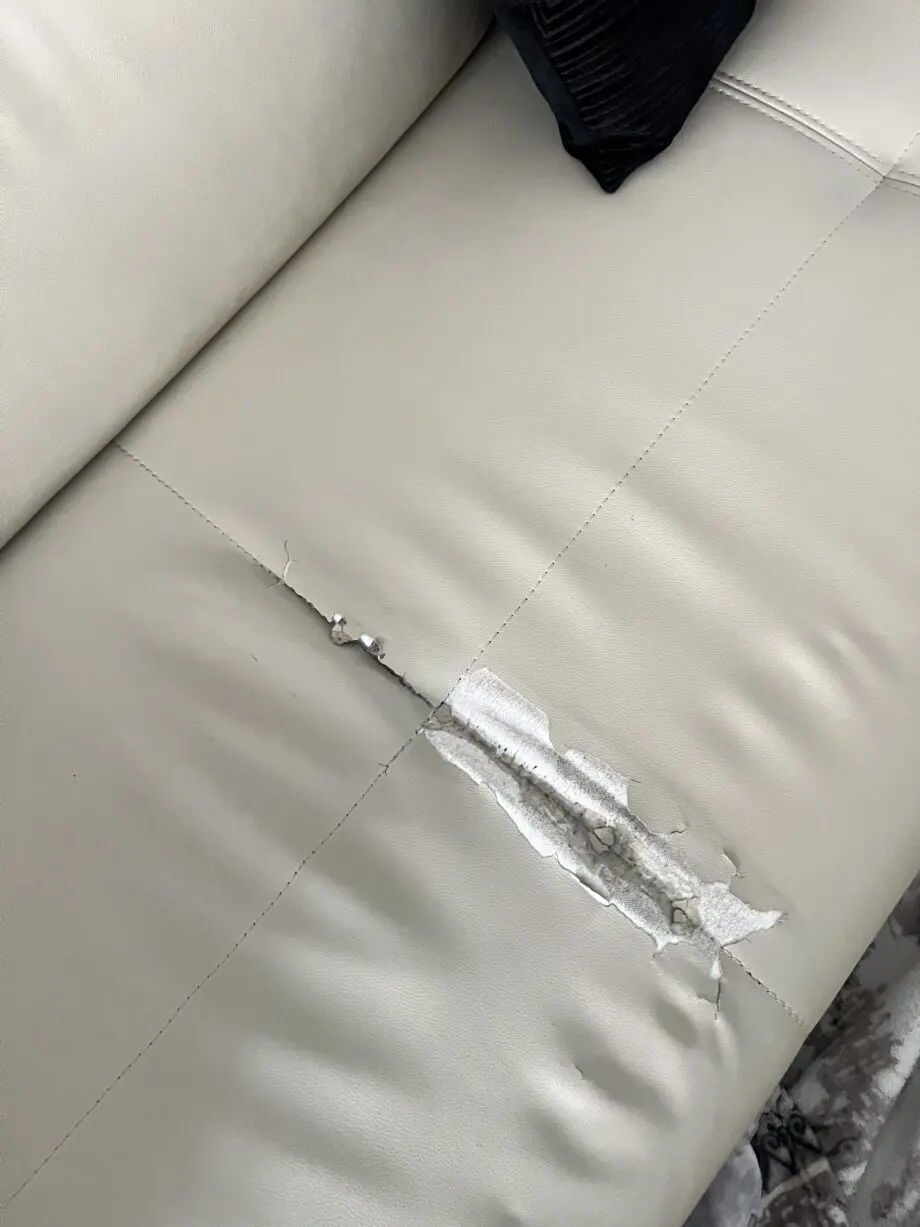 Modern beige/cream leather corner sofa with matching ottoman/footstool.