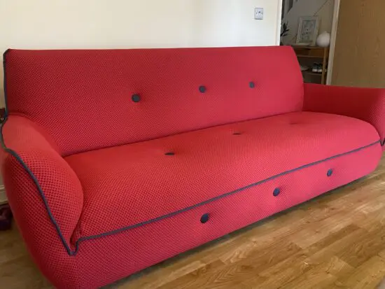 Red sofa with grey detail.