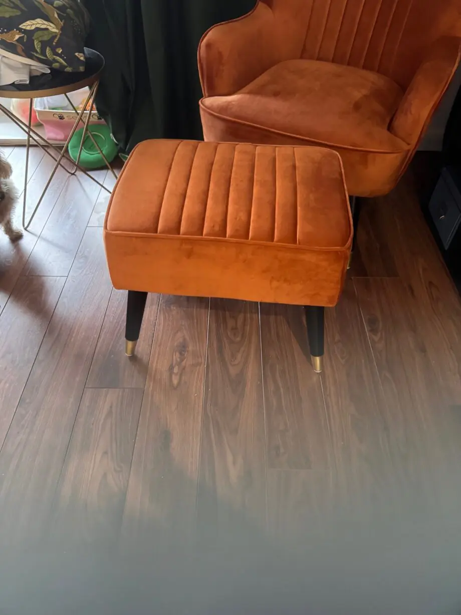 A orange sofa seat with stool