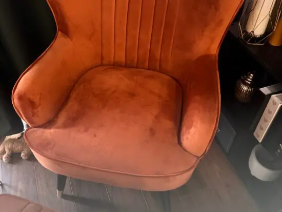 A orange sofa seat with stool
