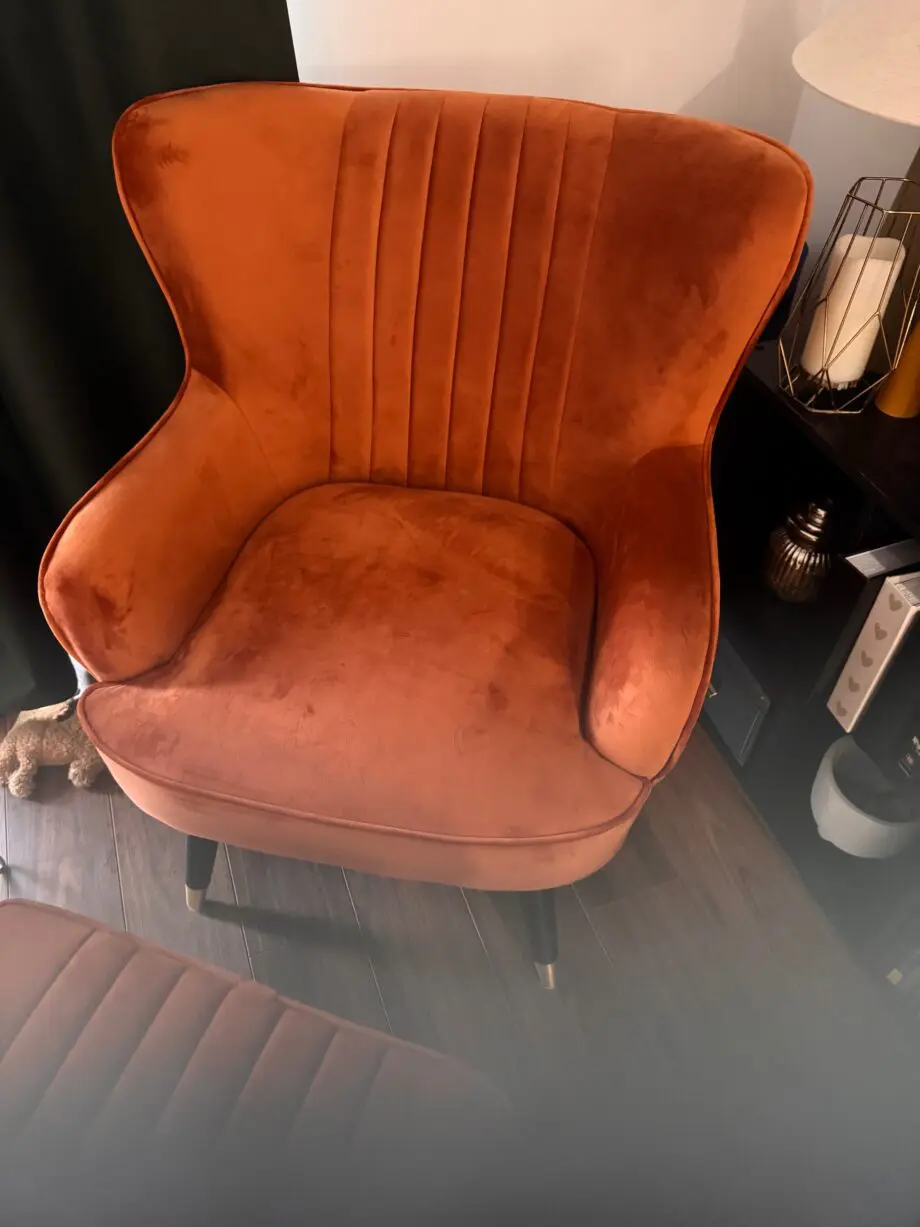 A orange sofa seat with stool