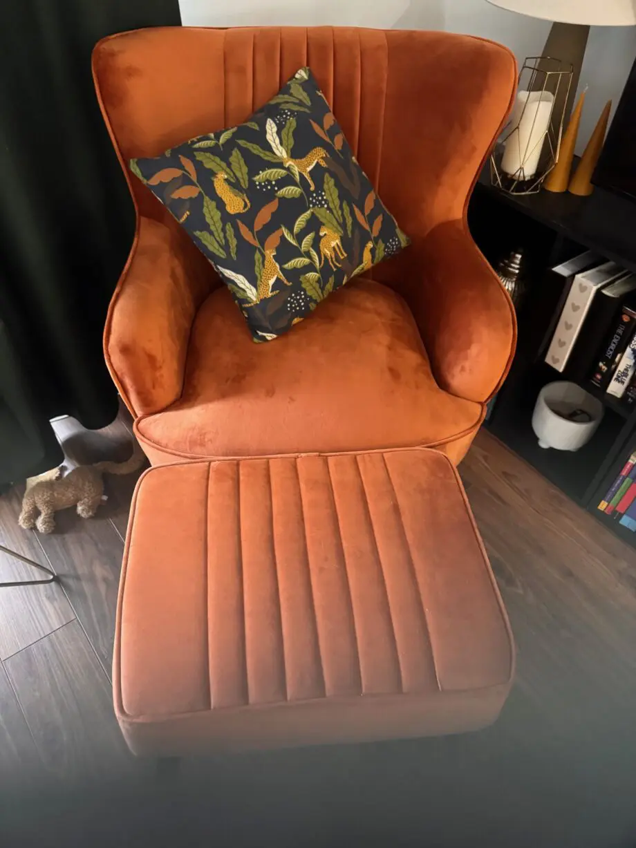 A orange sofa seat with stool
