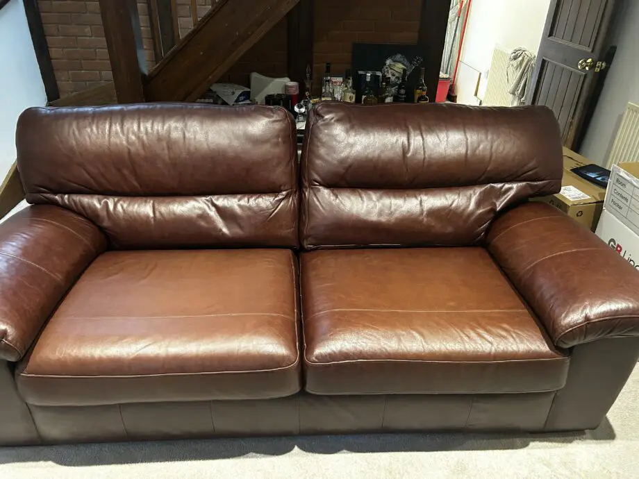 Brown leather 2 seater sofa with matching armchair and storage footstool. Excellent condition