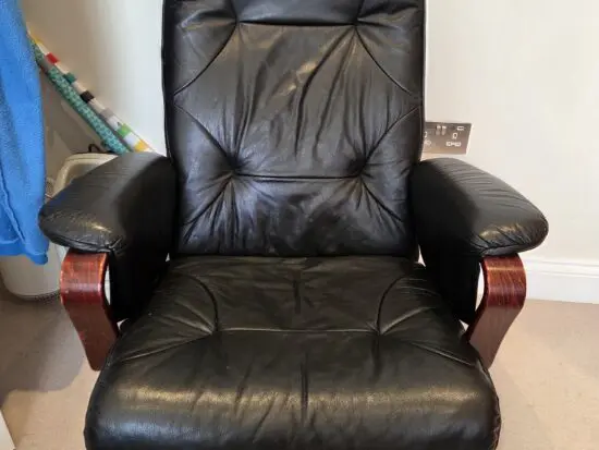 Black leather swivel armchair with varnish hand rests and feet