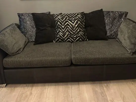DFS Sofa Set with with a black faux leather frame and dark grey fabric cushions,