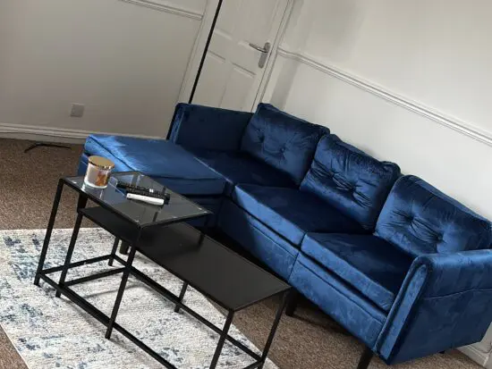 Blue velvet sofa with footstool