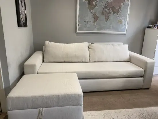 White upholstered 3-seat Living Spaces sofa with matching ottoman