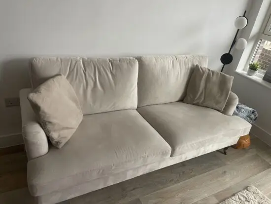 3 seater beige velvet sofa with antique brass castor legs