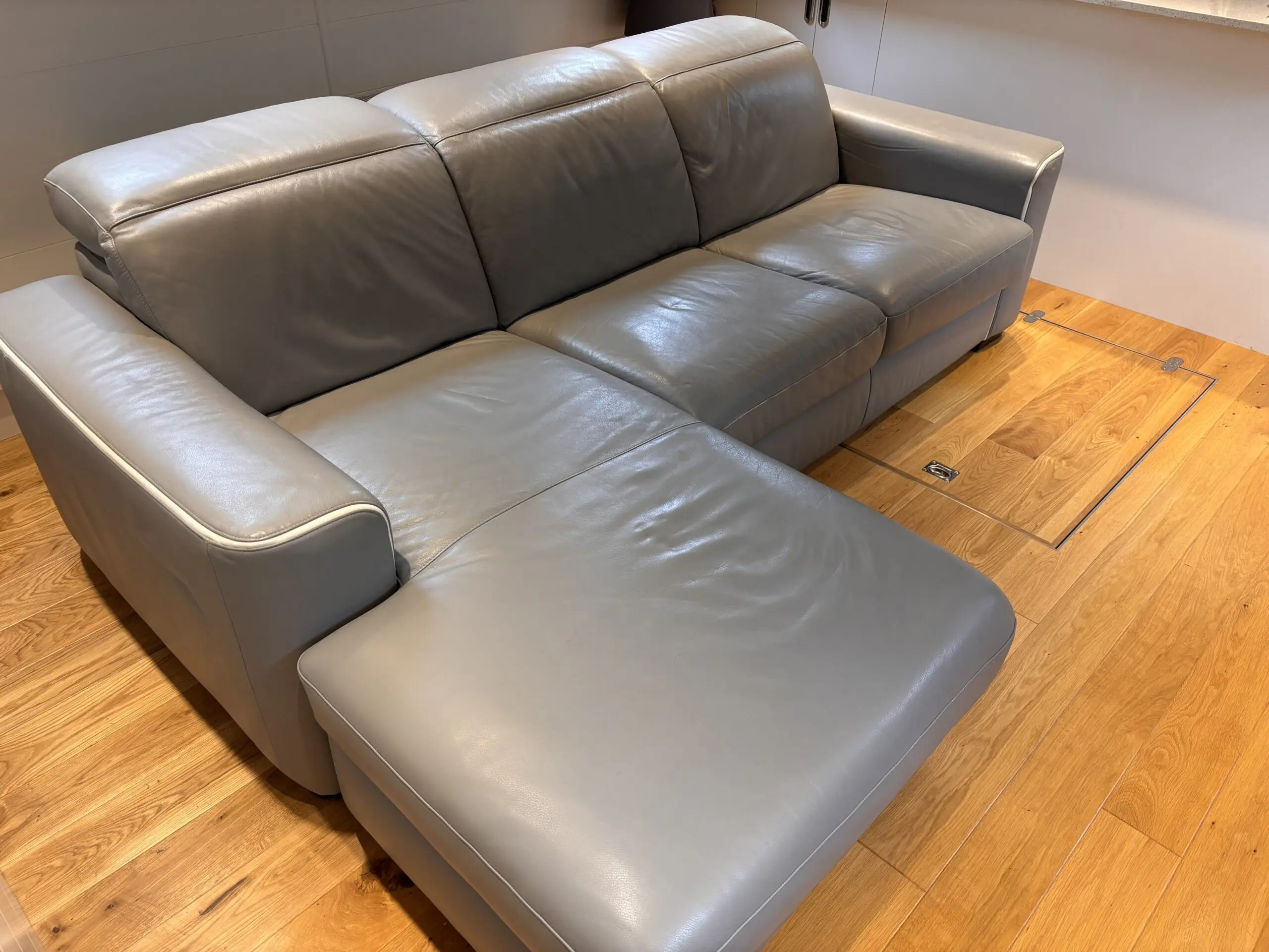 Grey leather Natuzzi 4 seater corner sofa bed, with storage chaise.