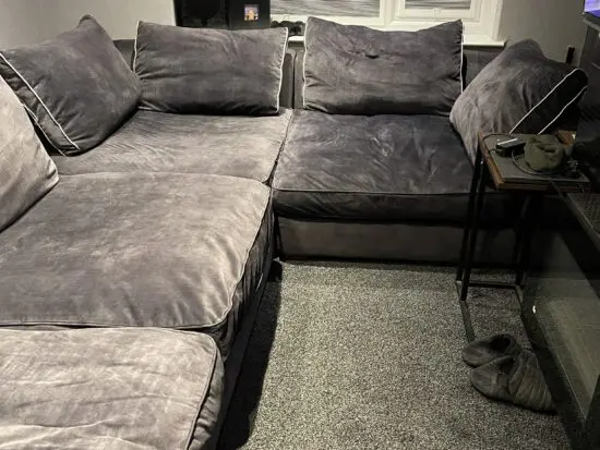 Grey suede corner sofa with foot stool