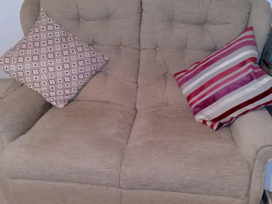 Oatmeal, buttoned, high-backed 2 seater sofa. In excellent condition, from pet and smoke free home. Very comfortable & compact for the more petite home.