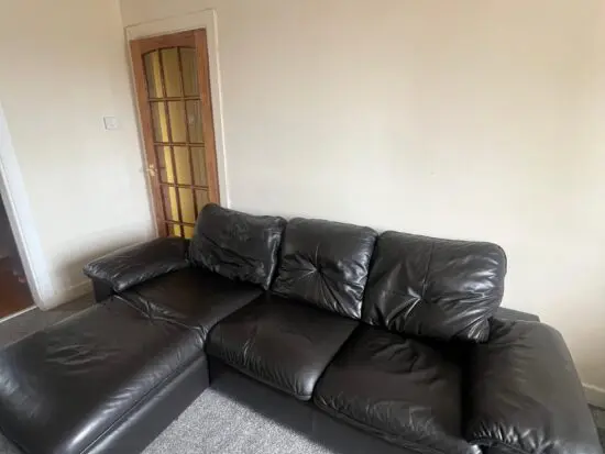 L-Shaped Black Leather Sofa – Minor Tear