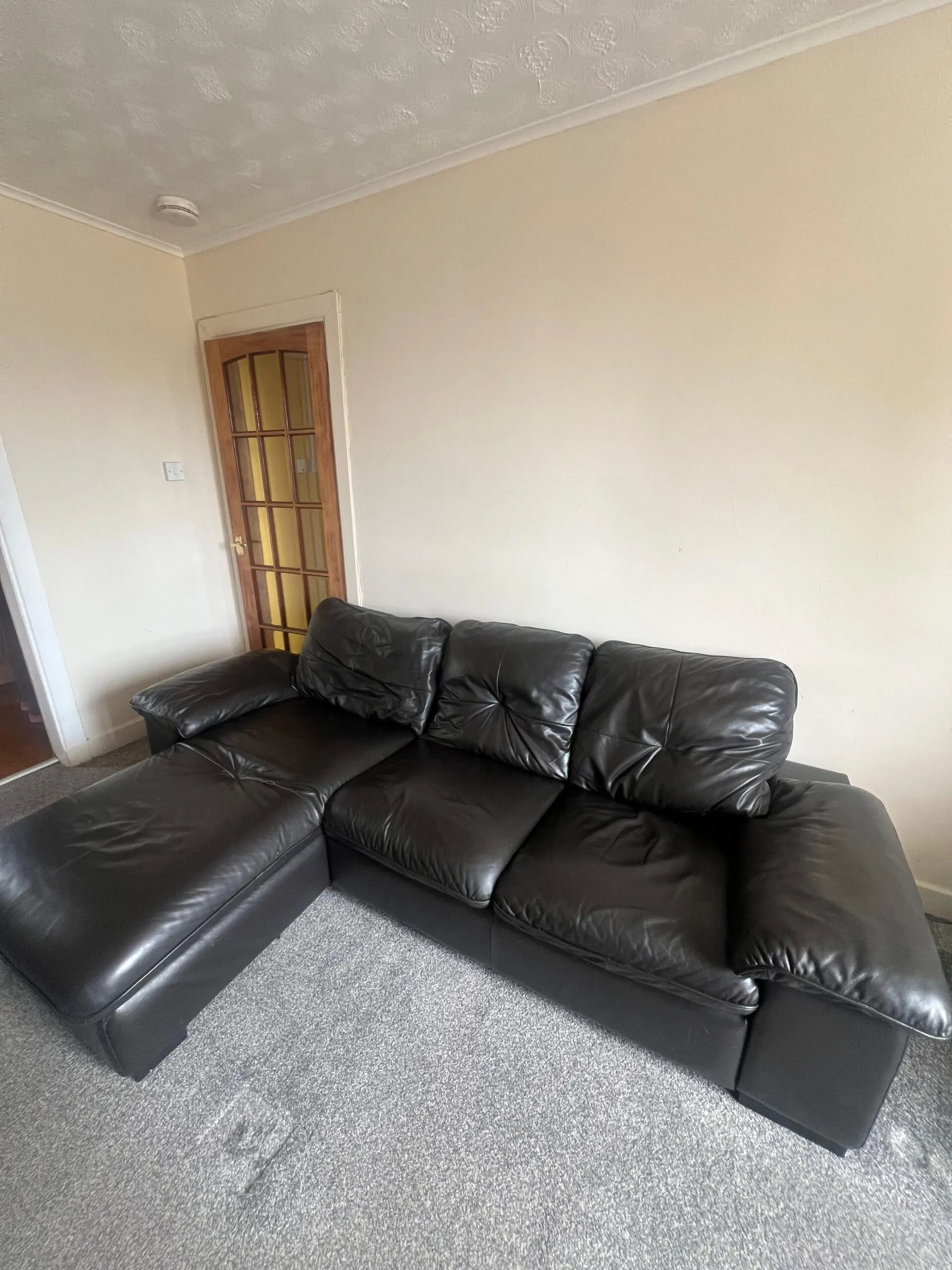 L-Shaped Black Leather Sofa – Minor Tear