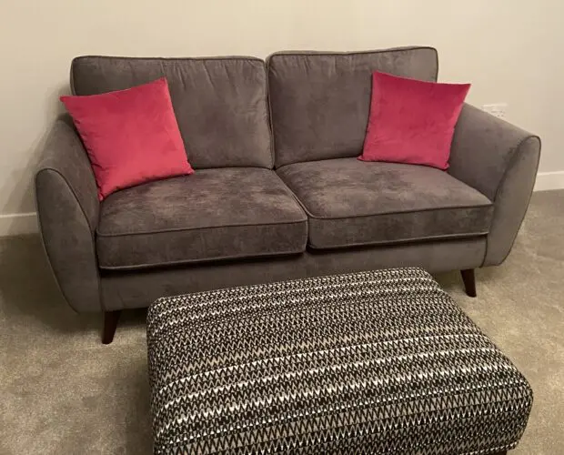 2 DFS charcoal grey Kyra 3-seater sofas with complementary footstool