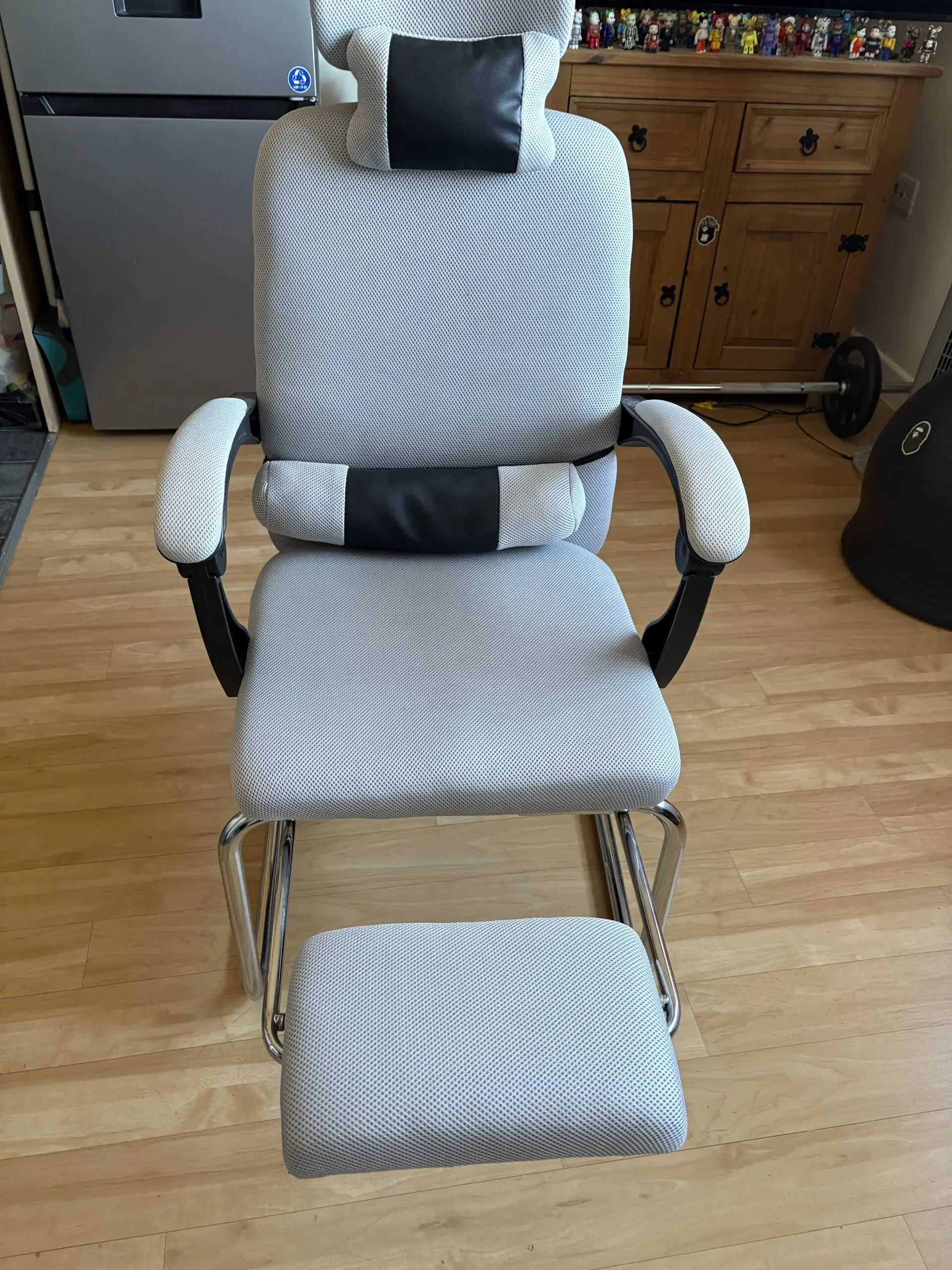 Ergonomic Chair with padded arms and silver metal base with footrest light grey