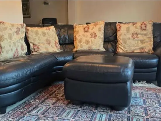 Black leather corner 5 seater sofa and matching footstool