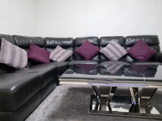 Dfs black corner sofa, leather, with foot stool