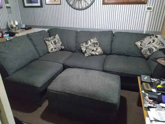 Large charcoal gray chord material hard wearing (L) shaped corner sofa and footstool.