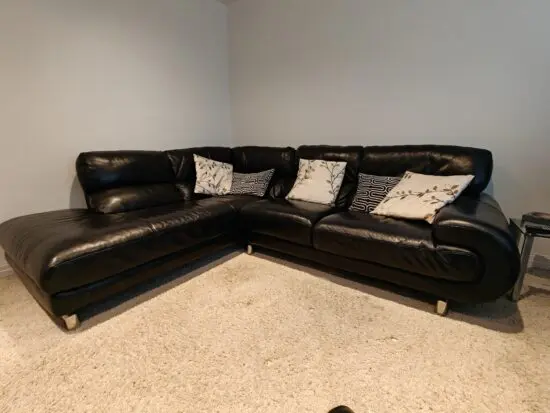 Black Leather corner sofa and footstool