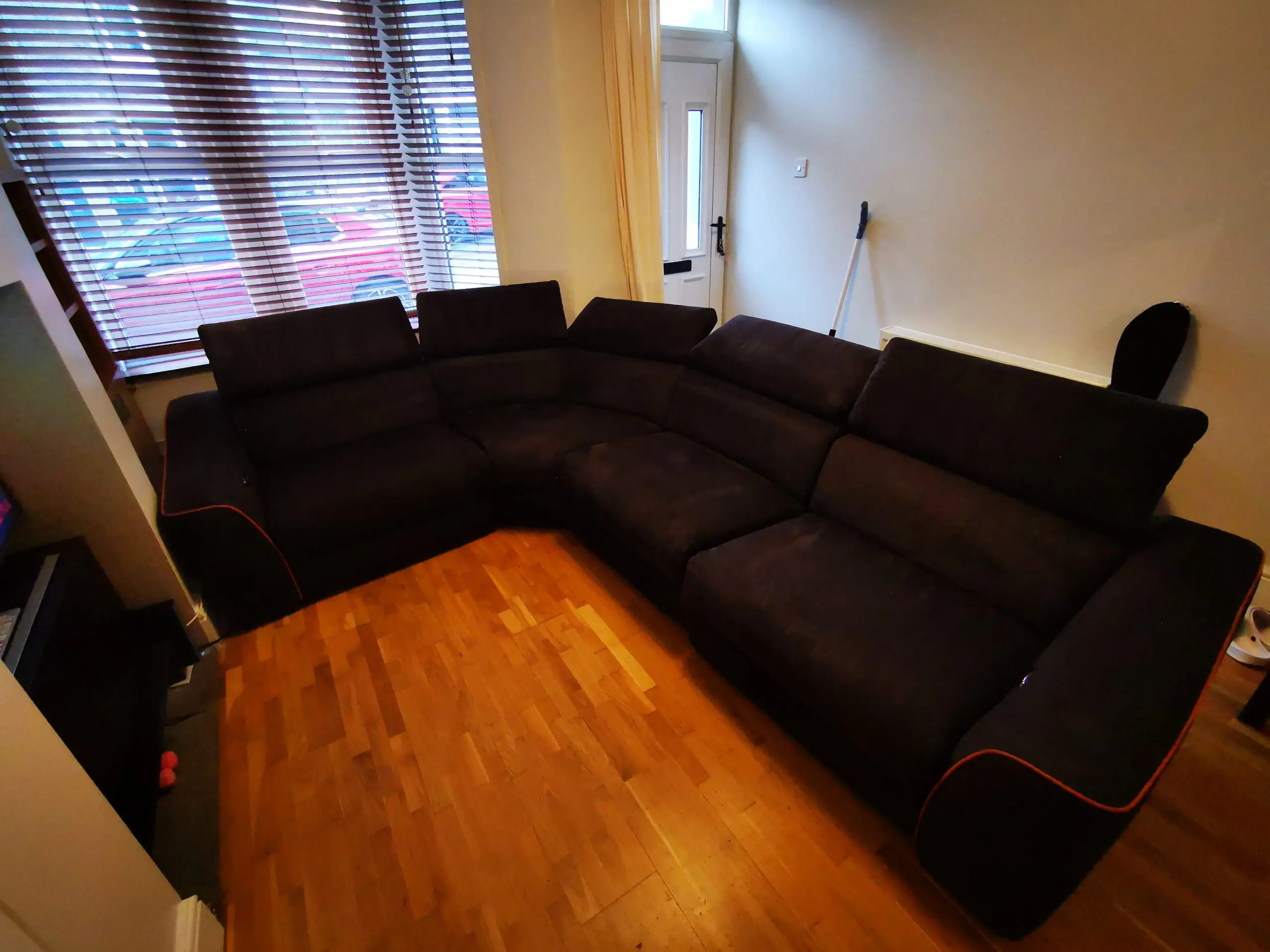 Furniture Village, corner sofa with 3 power recliner seats, black with orange piping